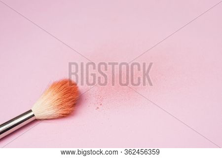 Makeup Brush Next To The Texture Of Scattered Colored Face Powder. A Brush Made Of Goat Hair Lies Ag