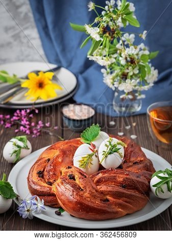 Challah Bread With Raisins, Cardamom And Vanilla On A White Dish. Near Boiled Eggs And A Cup Of Tea,