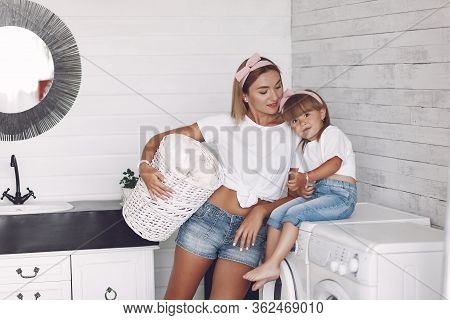 Mother And Daughter In A Bathroom Near Wash Mashine