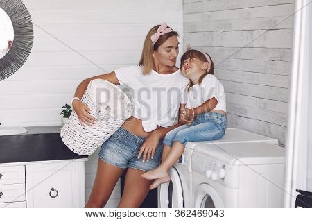 Mother And Daughter In A Bathroom Near Wash Mashine