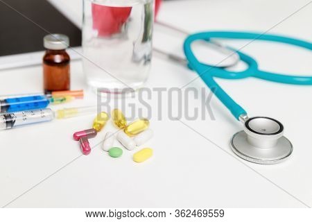 Pills And Medical Equiupments With Vaccine, Syringe And Stethoscope On Table. Healthcare And Medicin