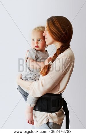 Little Baby Girl Or Boy And Her Mother At Home. Mother Is Holding And Tickling Her Baby, Babywearing