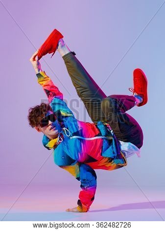 Guy Dancing Contemporary Dance In Studio. Neon Light Grey Background. Acrobatic Bboy Dancer. Break D