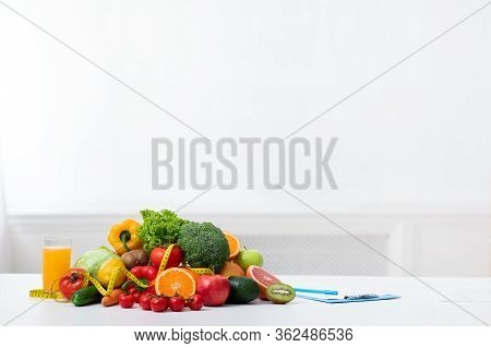 Dietologist Empty Workplace With Fruits, Vegetables, Measuring Tape And Medical Chart On Table, Copy