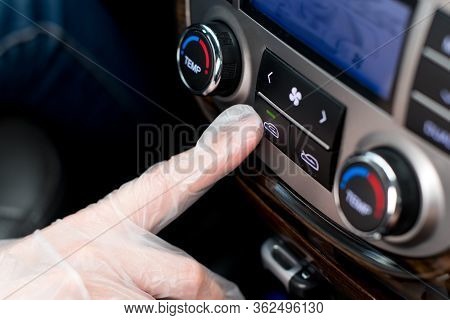 A Hand In A Medical Glove Presses The Air Recirculation Button In The Car, Closing Itself From Outsi