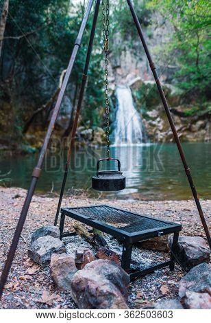 Vintage Black Teapot Hanging Over Campfire By Waterfall In Eksili, Antalya, Turkey.