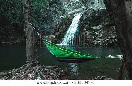 Green Hammock With Person In It Between Trees In Front Of A Waterfall In Eksili, Antalya, Turkey.