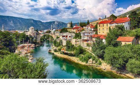 Fantastic Skyline Of Mostar With The Mostar Bridge, Houses And Minarets, During Sunny Day. Location: