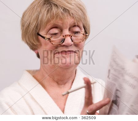 Mujer leyendo su papel de mañana