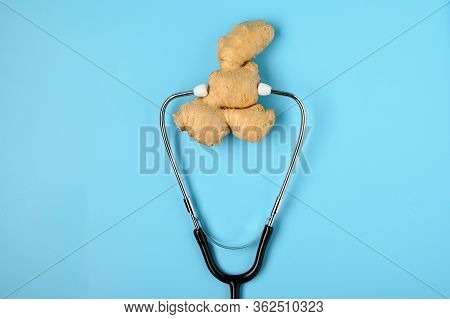 .natural Medicine. Immunostimulating Products: Ginger Root. Ginger And Stethoscope On A Blue Backgro