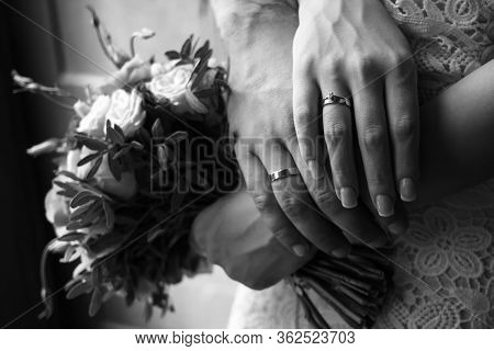Hands Of The Bride And Groom With Wedding Rings, Bride Holds A Wedding Bouquet In Hands, The Groom H