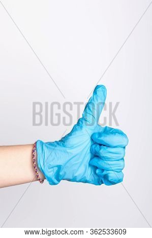 Female Hand In A Blue Medical Glove Show A Raised Thumb Up During Quarantine Of Coronavirus Infectio