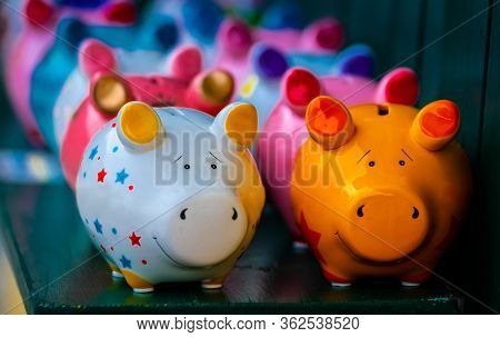 Colorful ceramic pig shape copycats on the wooden shelf