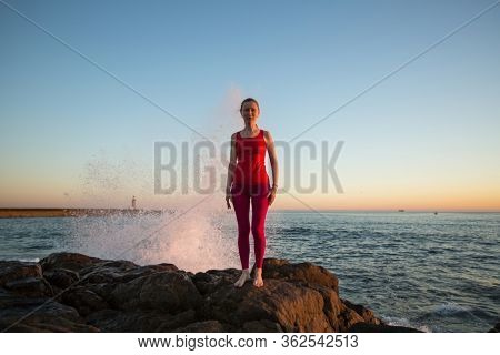 Woman prepares before yoga classes on the atlanic ocean coasts.