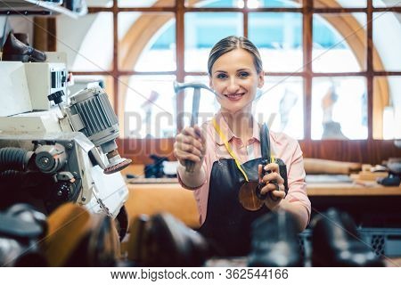 Business portrait of proud owner in her small cobbler workshop