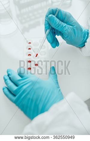 COVID-19. Doctor, microbiologist, scientist in a protective suit, makes a study of coronavirus in the laboratory. Coronavirus test.