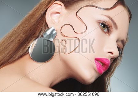 Beauty portrait, hair styling. Close-up of a beautiful young woman with fresh shining make-up and refined elegant hairstyle.