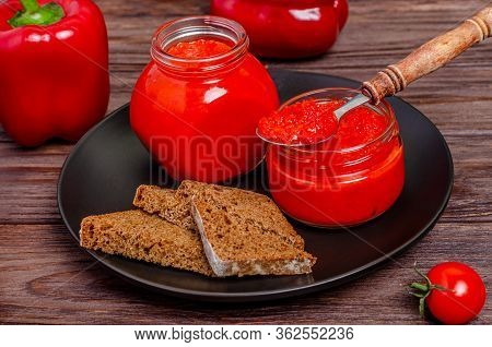 Ajvar Or Pindjur Red Vegetable Spread Or Pepper Paprika And Tomato Mousse In Glass Jars In A Black P