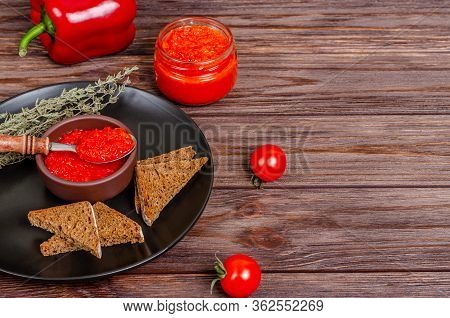 Ajvar Or Pindjur Red Vegetable Spread Or Pepper Paprika And Tomato Mousse In A Clay Bowl In A Black 