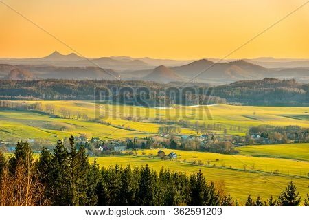 Hilly Landscape Illuminated By Evening Sunset. Green Grass Fields And Hills On The Horizont. Vivid S