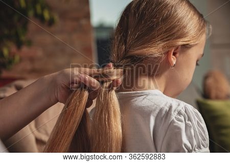 Hairdo, Hairstyle. Mother And Daughter During Self-insulation At Home While Quarantined, Family Time