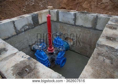 Gate Valves In Valve Pit Of The Underground Piping Networks. Laying Water System Pipeline At Constru
