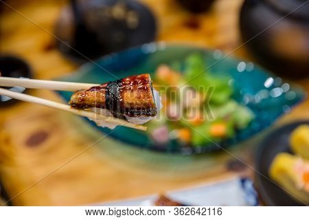 Close Up Chopsticks Hold On Sushi Freshwater Eel Grilled. Japanese Food For Healthy. Unagi Sushi, Pr