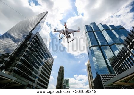 Drone With High Resolution Digital Camera Flying Over City . An Aerial View Of A Flying Multi-copter