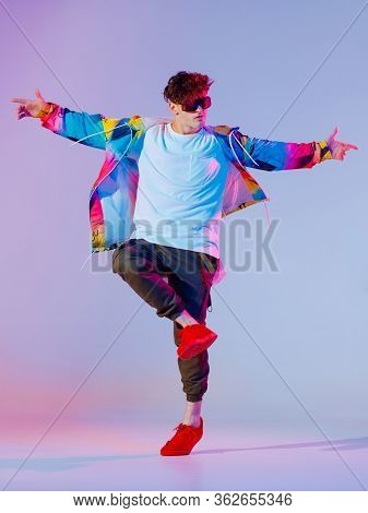 Guy Dancing Contemporary Dance In Studio. Neon Light Grey Background. Acrobatic Bboy Dancer. Break D