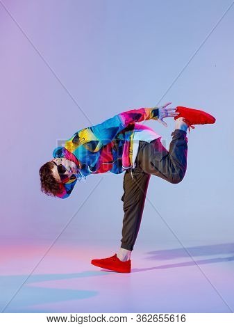 Guy Dancing Contemporary Dance In Studio. Neon Light Grey Background. Acrobatic Bboy Dancer. Break D