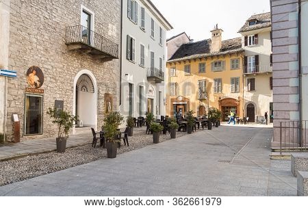 Pedestrian Street With Typical Outdoor Bars And Shops In The Historic Center Of Domodossola, Italy.