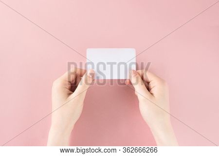 Female Hand Holding White Business Card On Colorful Pink Background. Template, Mockup, Blank For Web