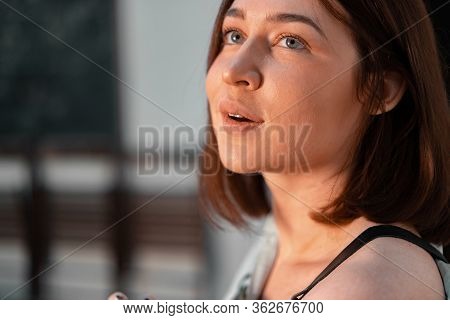 Portrait Of Beautiful Smiling Woman Sculptor Artist In Modern Workshop Studio. Face Illuminated With