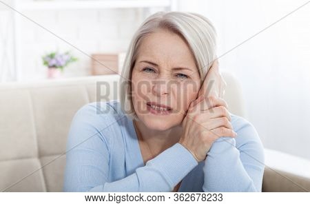 Tinnitus. Closeup Up Side Profile Sick Female Having Ear Pain Touching Her Painful Head.