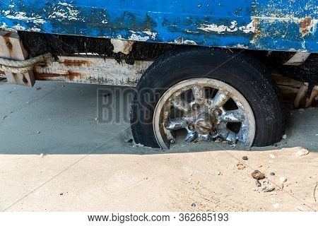 The Old Wheel Get Stuck In The Sands Of The Dunes In The Desert. Wheel In Countryside Landscape With