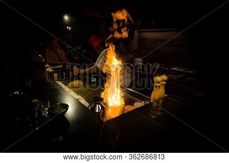 May, 2018 - Ari Atoll, Maldives: Happy Teppanyaki Chef Cooking Vegetables At Teppan In A Japanese St