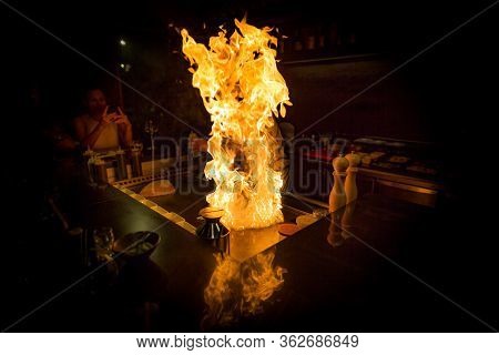 May, 2018 - Ari Atoll, Maldives: Happy Teppanyaki Chef Cooking Vegetables At Teppan In A Japanese St