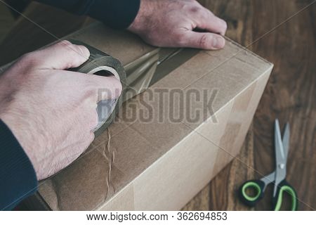 Close-up Of Person Sealing Up Shipping Box With Parcel Tape, Pruchase Return And Return Of Goods Con
