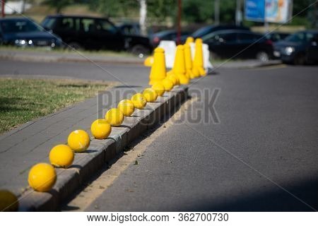 Protection Of The Sidewalk From Parking. Yellow Balls Lined Up In A Row. There Are Such Columns In M