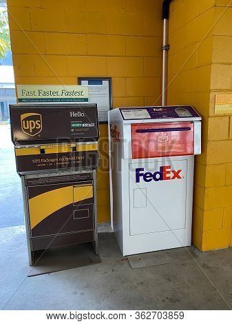 Orlando,fl/usa-4/10/20:  A Ups And Fedex Drop Boxes In A Garage Next To An Office Building