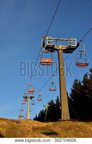 Ski Chair Lift In The Mountains And Pillars. Vertical Photo.