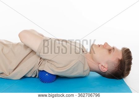 Handsome Man Shows Exercises Using The Ball With Spikes