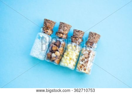 Picture With Soft Focus Of Four Tiny Glass Jar With Buckwheat, Millet, Sugar And Barley On Blue Back