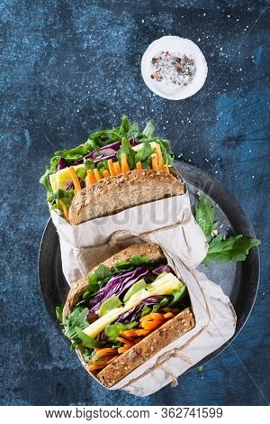 Healthy Sandwiches With Argula, Carrot, Cheese, Red Cabbage, Wrapped In Craft Organic Paper On A Dar