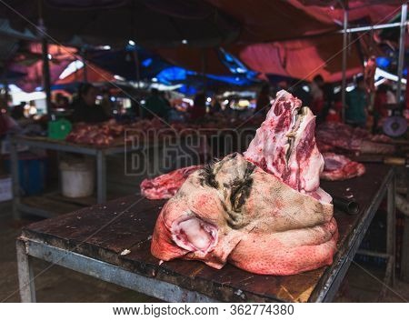 Pig's head butchered ready to sale at the Bac Ha Market. backgound blurry and unrecognizable person