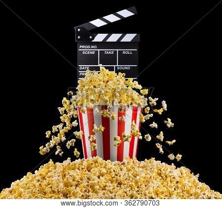 Flying Popcorn And Film Clapper Board Isolated On Black Background