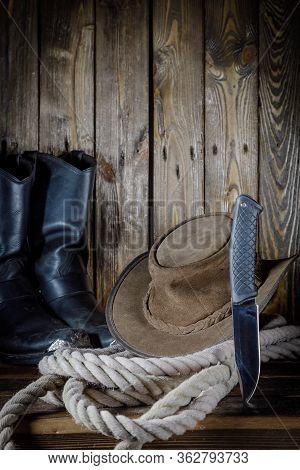 Cowboy Hat, Boots And Rope On Wooden Background