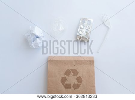 Brown Paper Bag And Scattered Rubbish Around It. Crumpled Into A Ball Paper, Plastic Fork, Plastic G