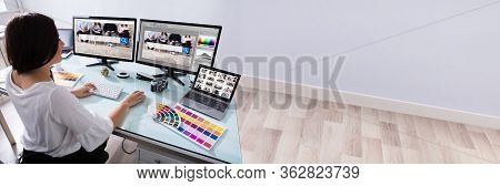 Graphic Designer Artist Working On Multiple Computer Screens