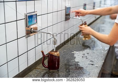 Water Is Poured Into A Special Cup In The Pump Room Of Mineral Waters,